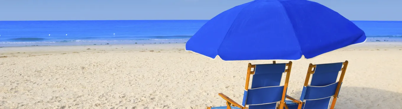 Two beach chairs with an umbrella on the beach
