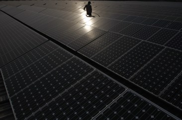 A maintenance worker cleans solar panels at a power station in New Delhi, India.