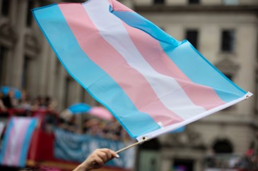 A trans flag is being waved.