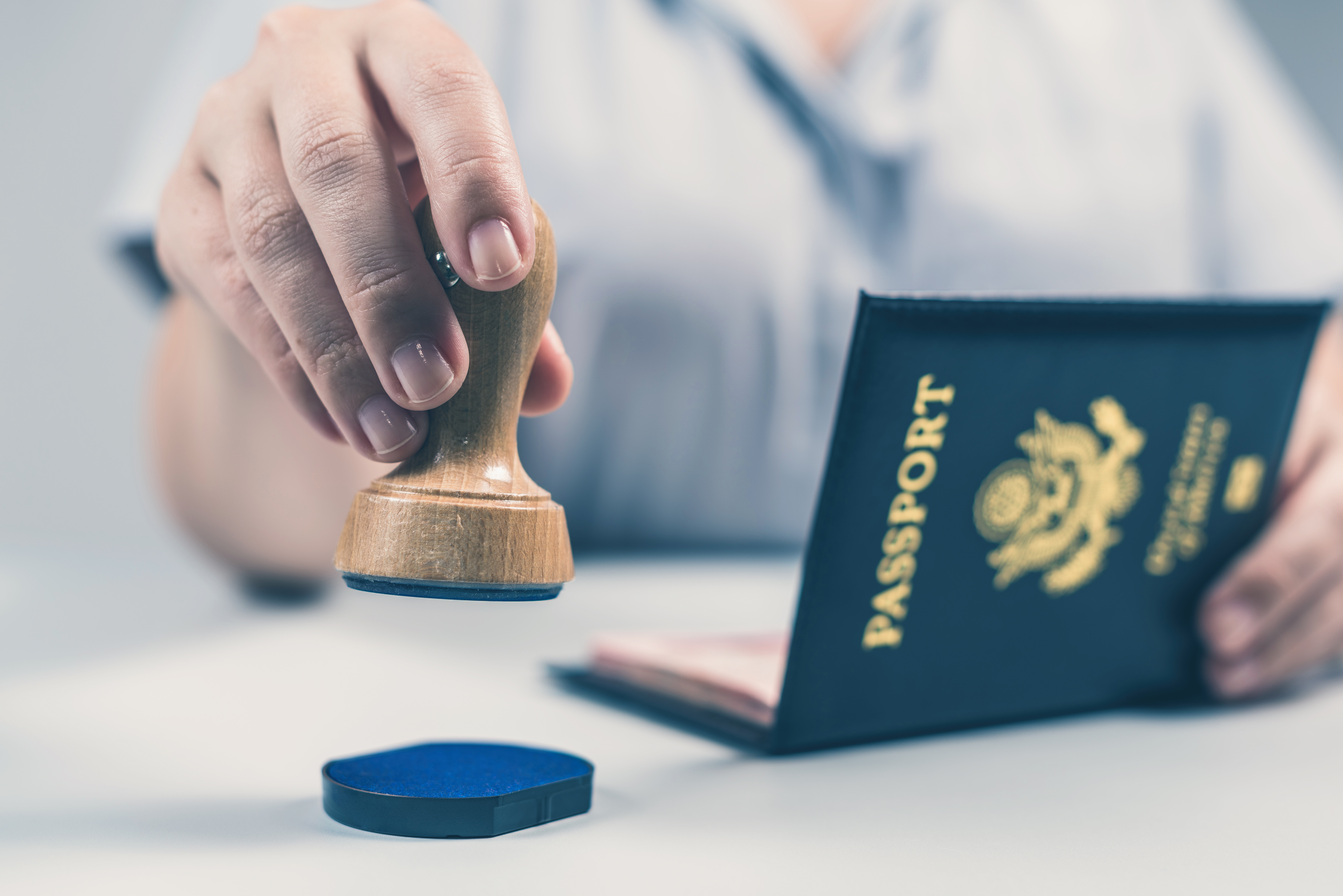 Border control officer stamps U.S. passport.