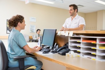 Nurse talking to a patient at a computer