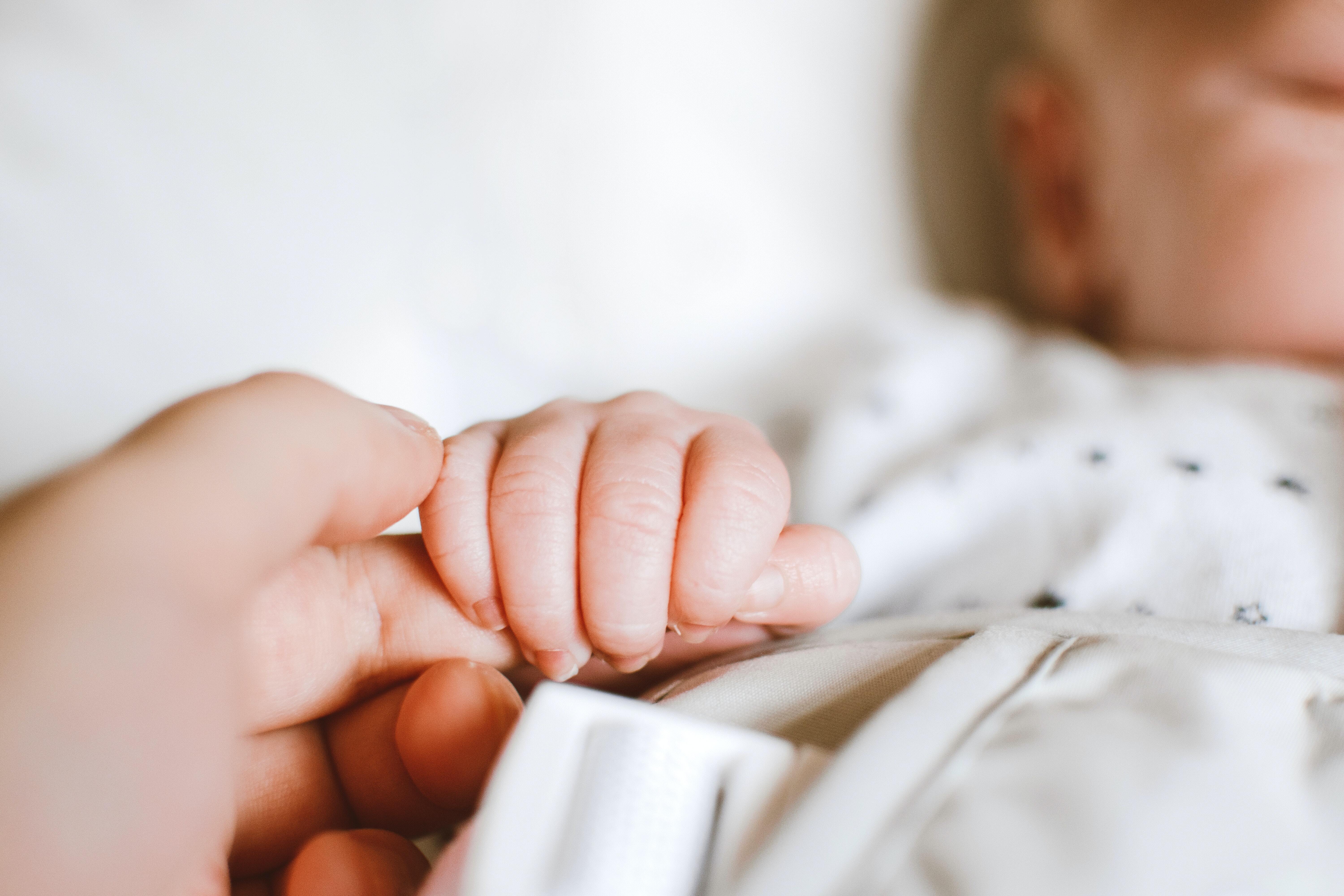 Baby holding finger