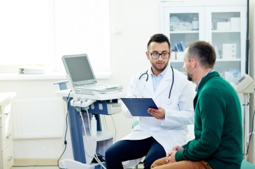 A doctor and patient discuss the patient's chart.