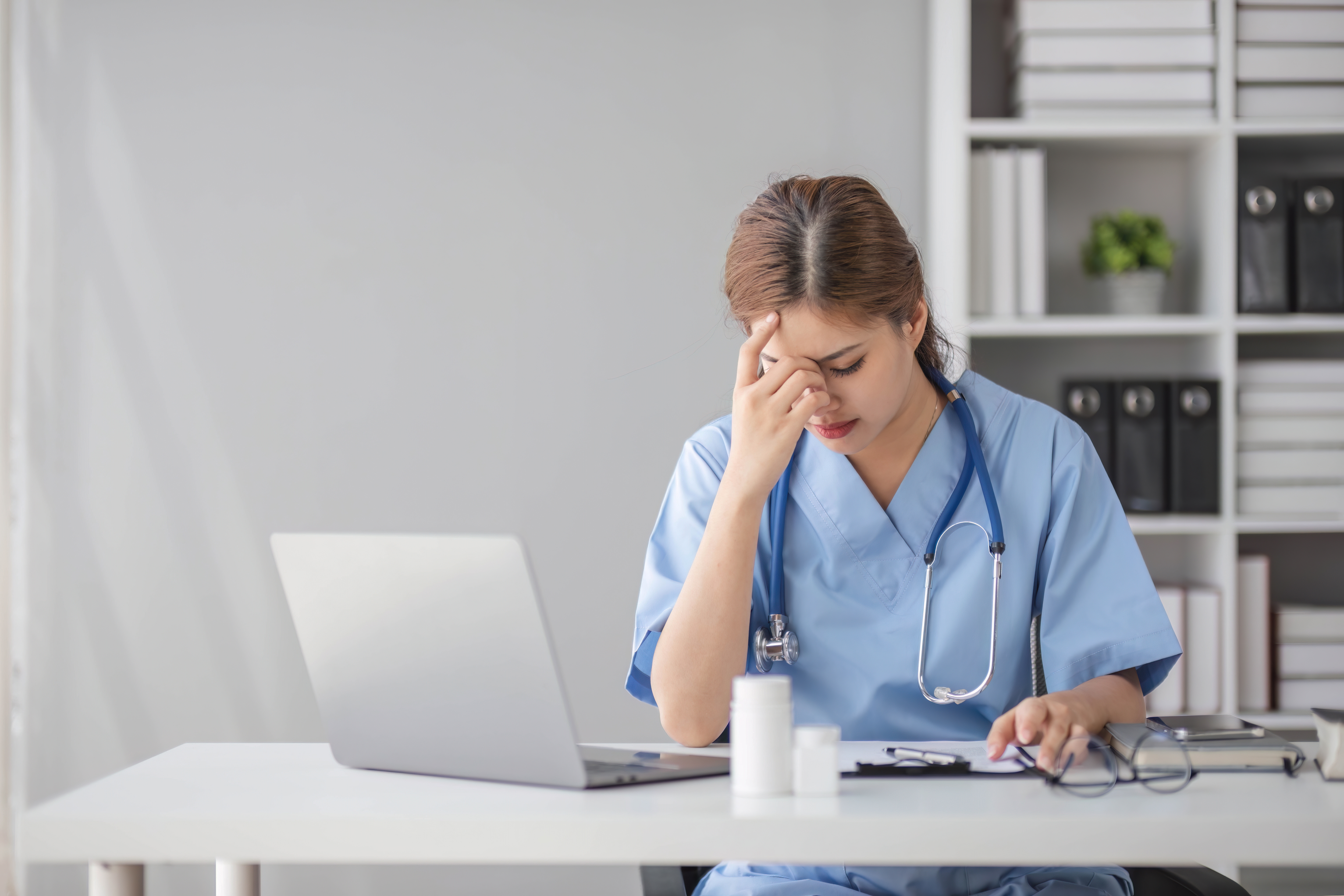 Nurse with her head in her hands.