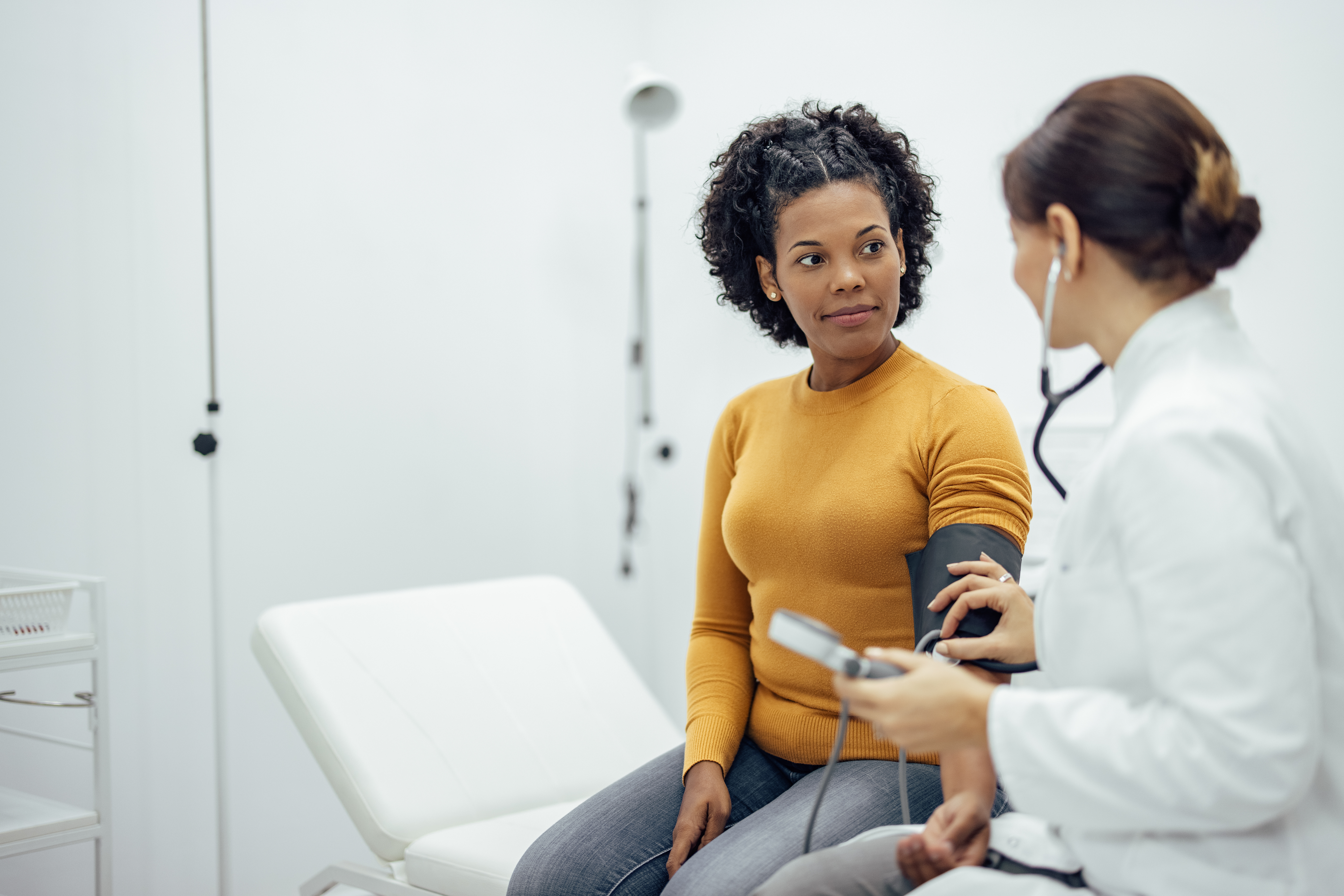 A doctor measures a woman's blood pressure.
