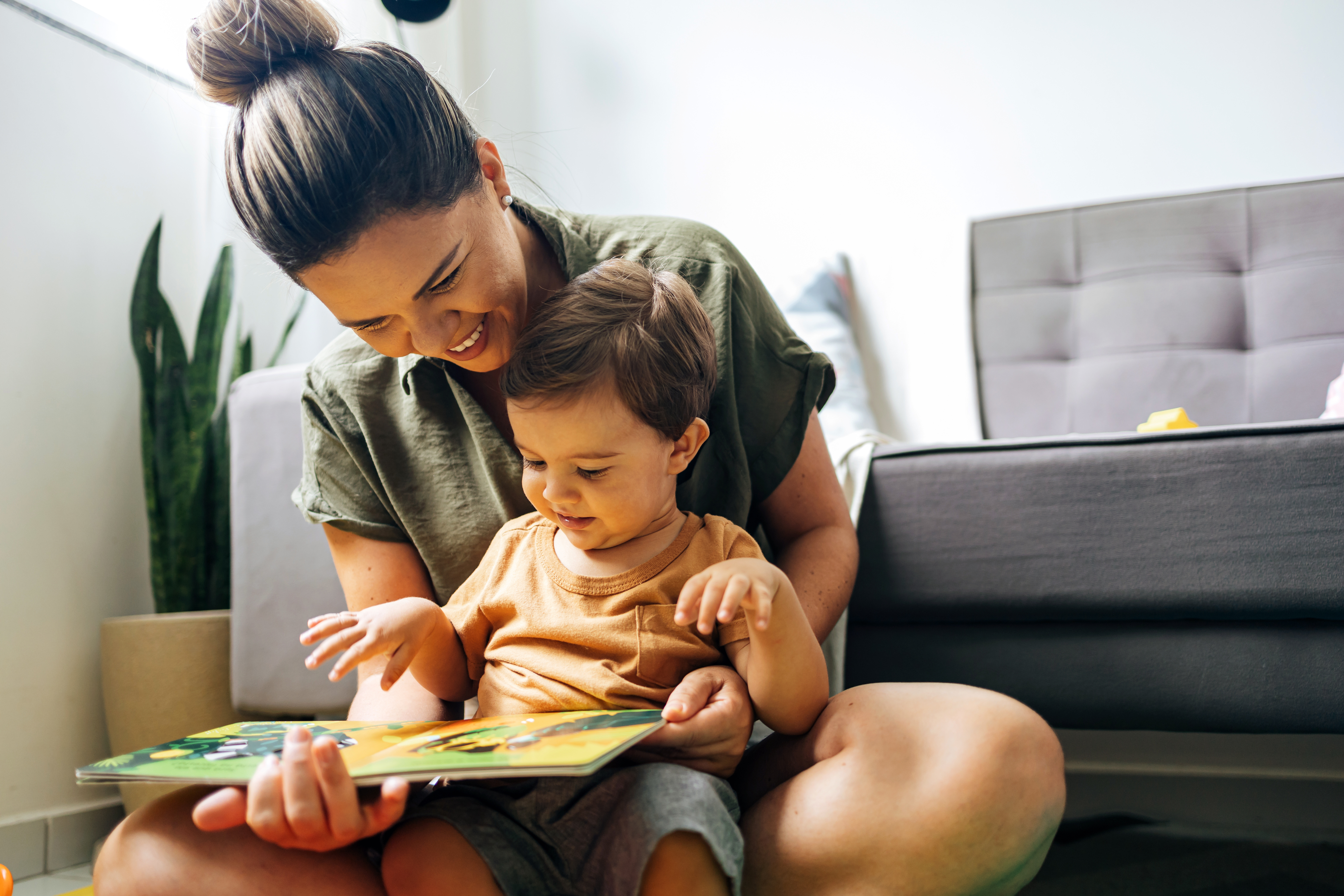 A mom reads a picture book to her young child.