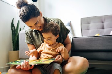 A mom reads a picture book to her young child.