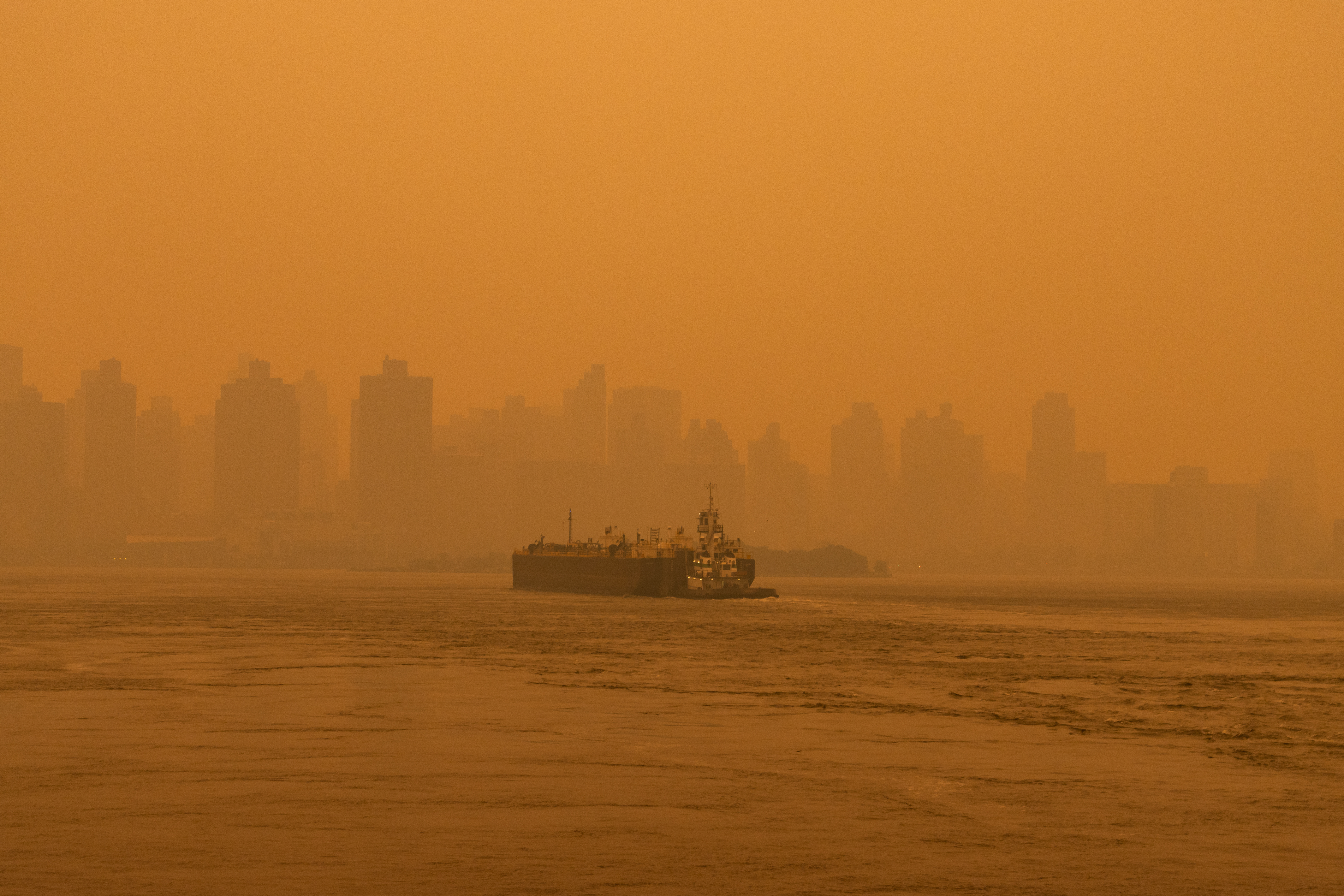 Barge boat on the East River in New York City clouded by air pollution from wildfires.