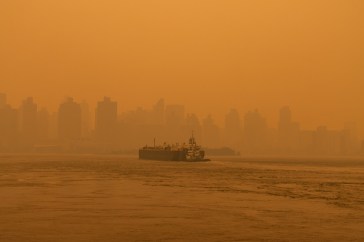 Barge boat on the East River in New York City clouded by air pollution from wildfires.