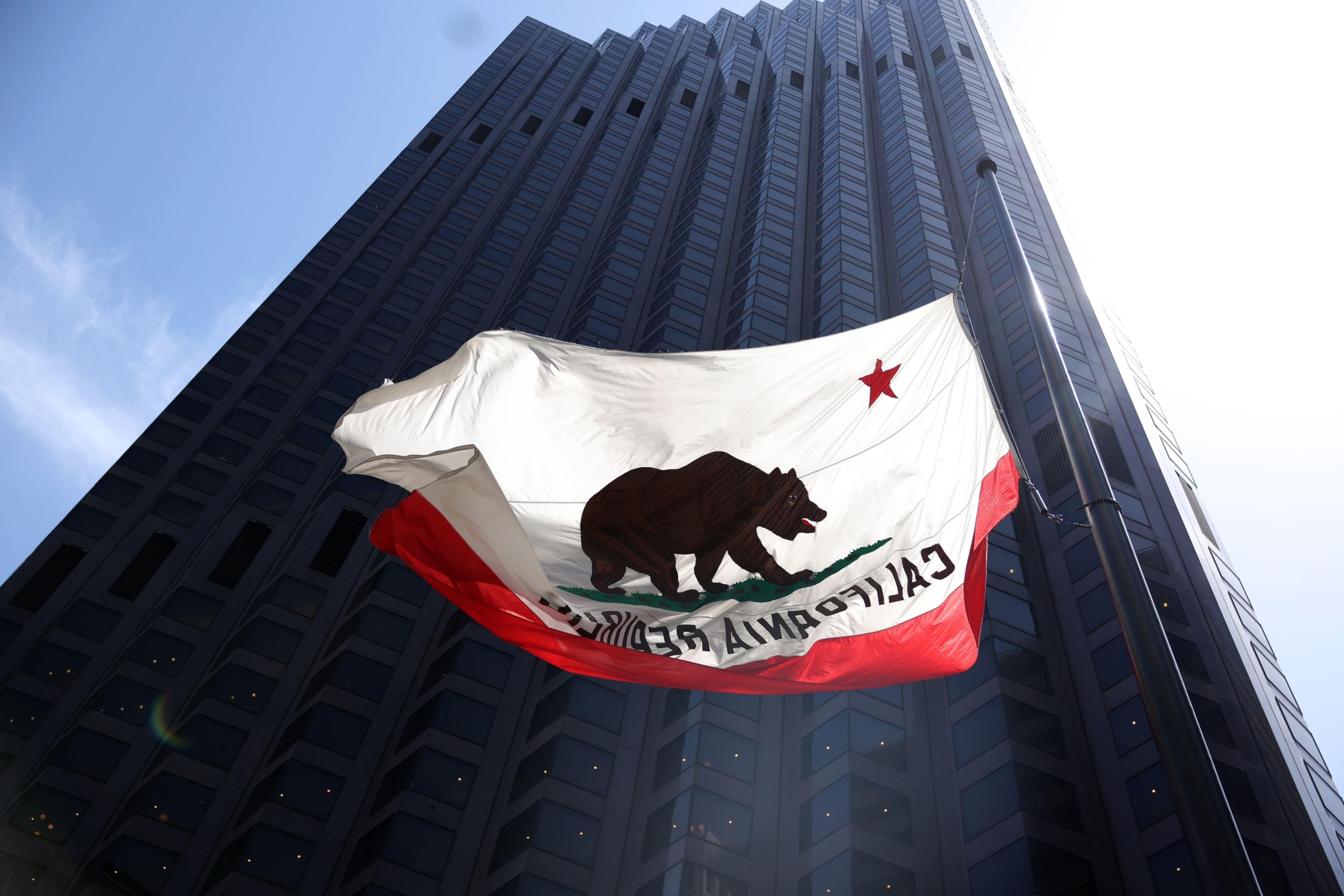 California state flag waves in front of a building.
