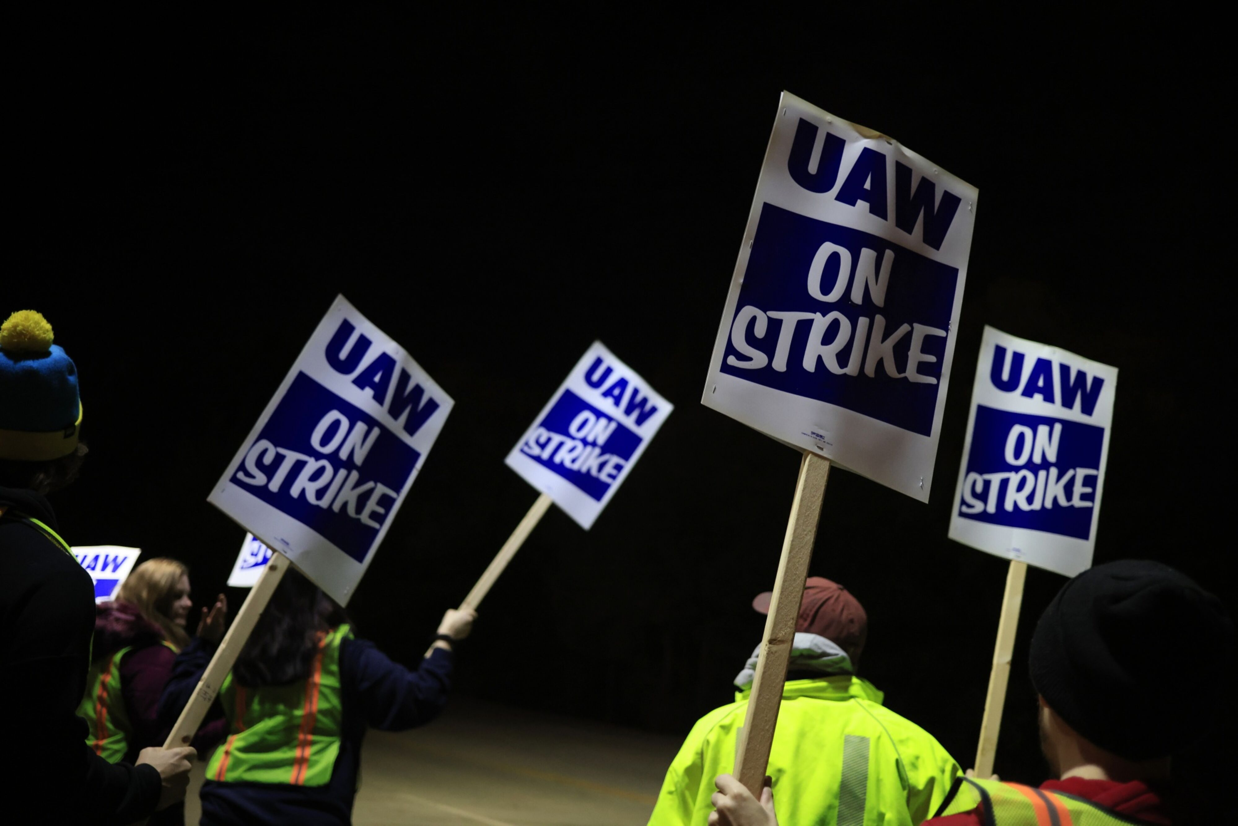 The United Auto Workers hold strike signs.