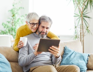 A senior couple looks at a tablet together.