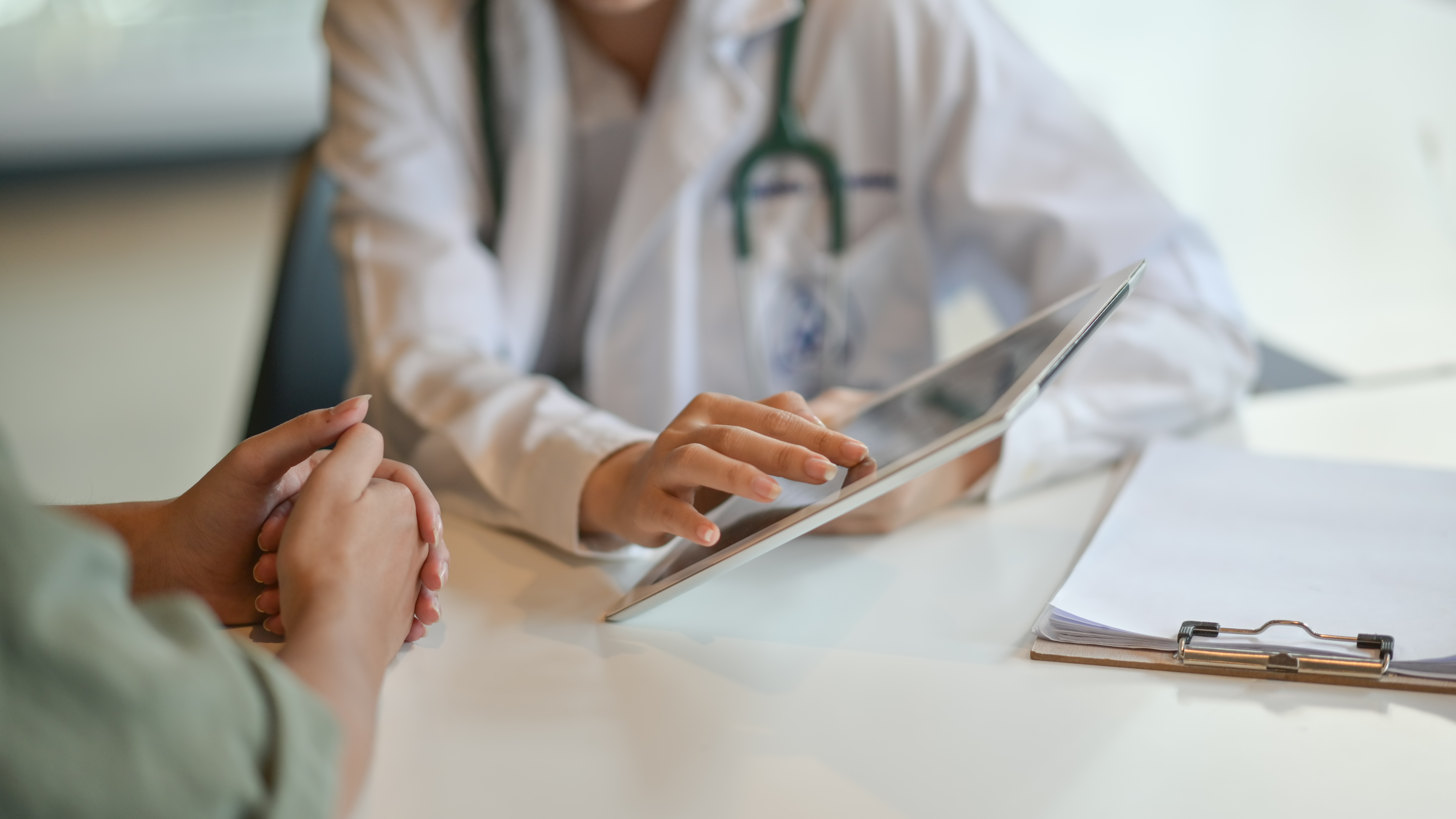 A doctor showing a patient information on a digital tablet.