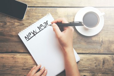 Woman writing out a list of goals for the new year