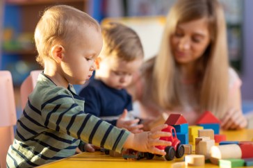 Baby playing with a toy car while at daycare