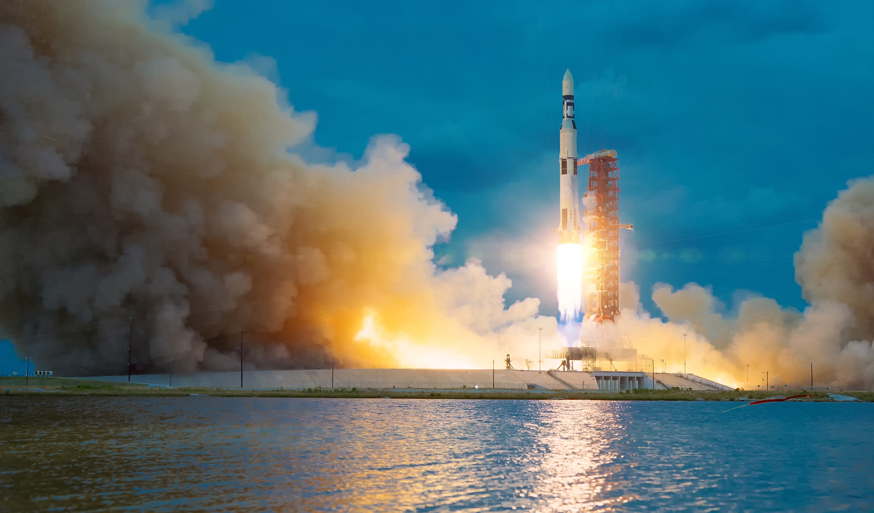A rocket takes off into a dark blue sky, smoke flying around it.