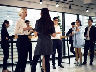 People standing in an office with wine glasses in their hands