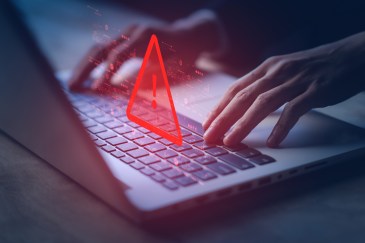 Red system hacked warning alert on laptop.