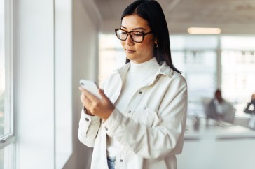 Woman of Asian descent texting on her phone
