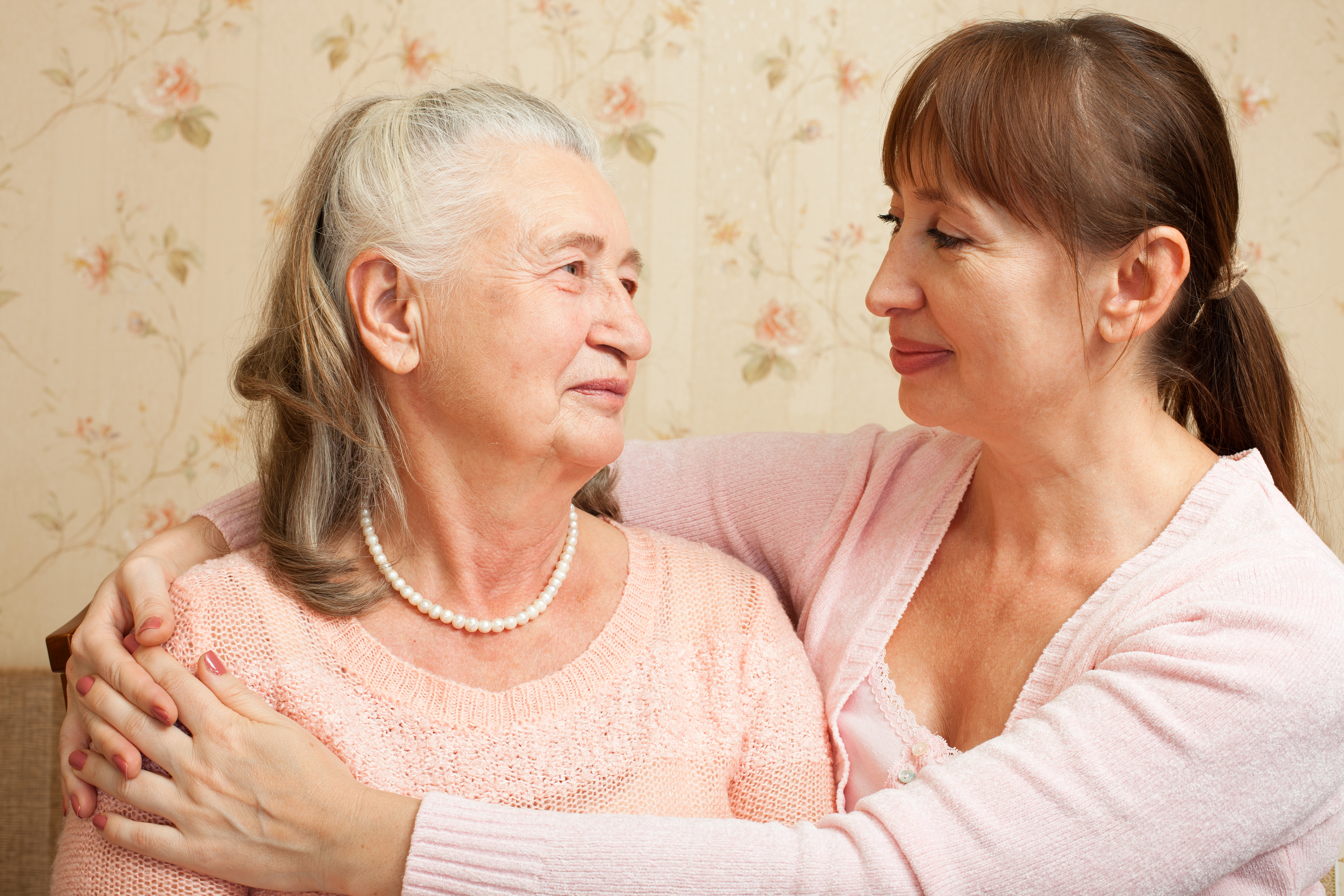 Daughter with arms around older mother