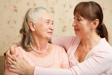 Daughter with arms around older mother