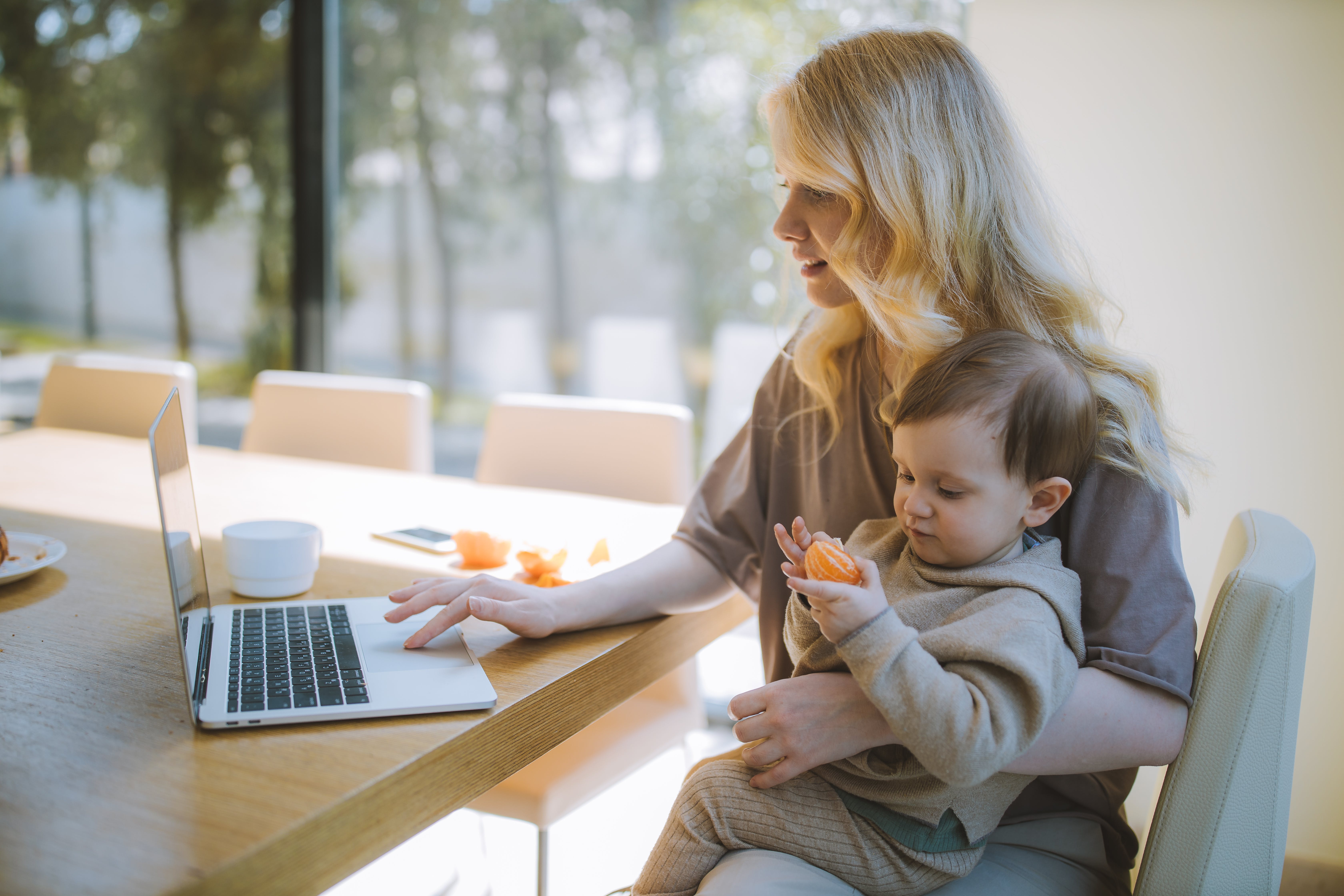 Mom holding child and working