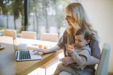 Mom holding child and working