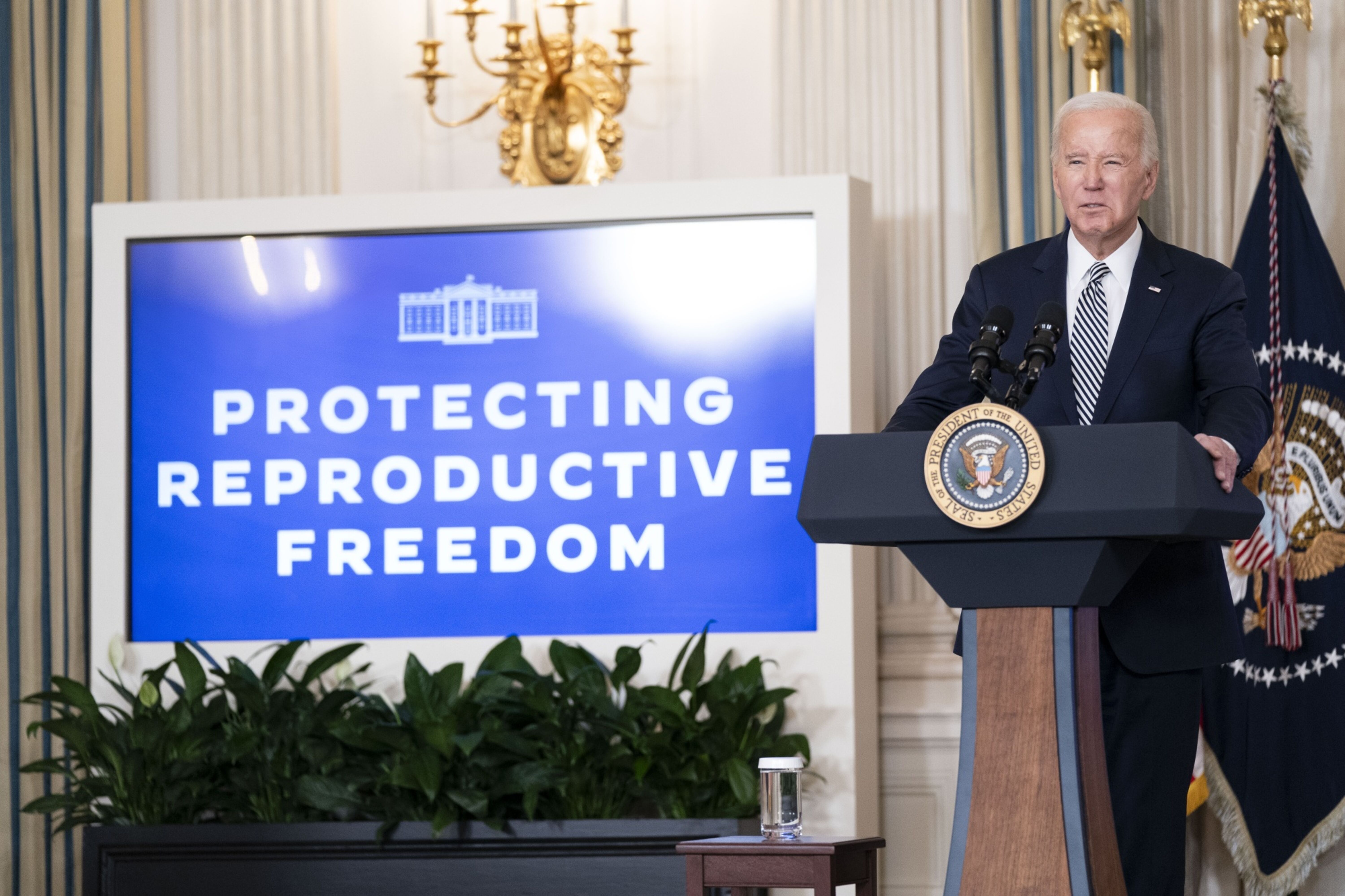 President Biden at press conference, next to a screen that reads "Protecting reproductive freedom."