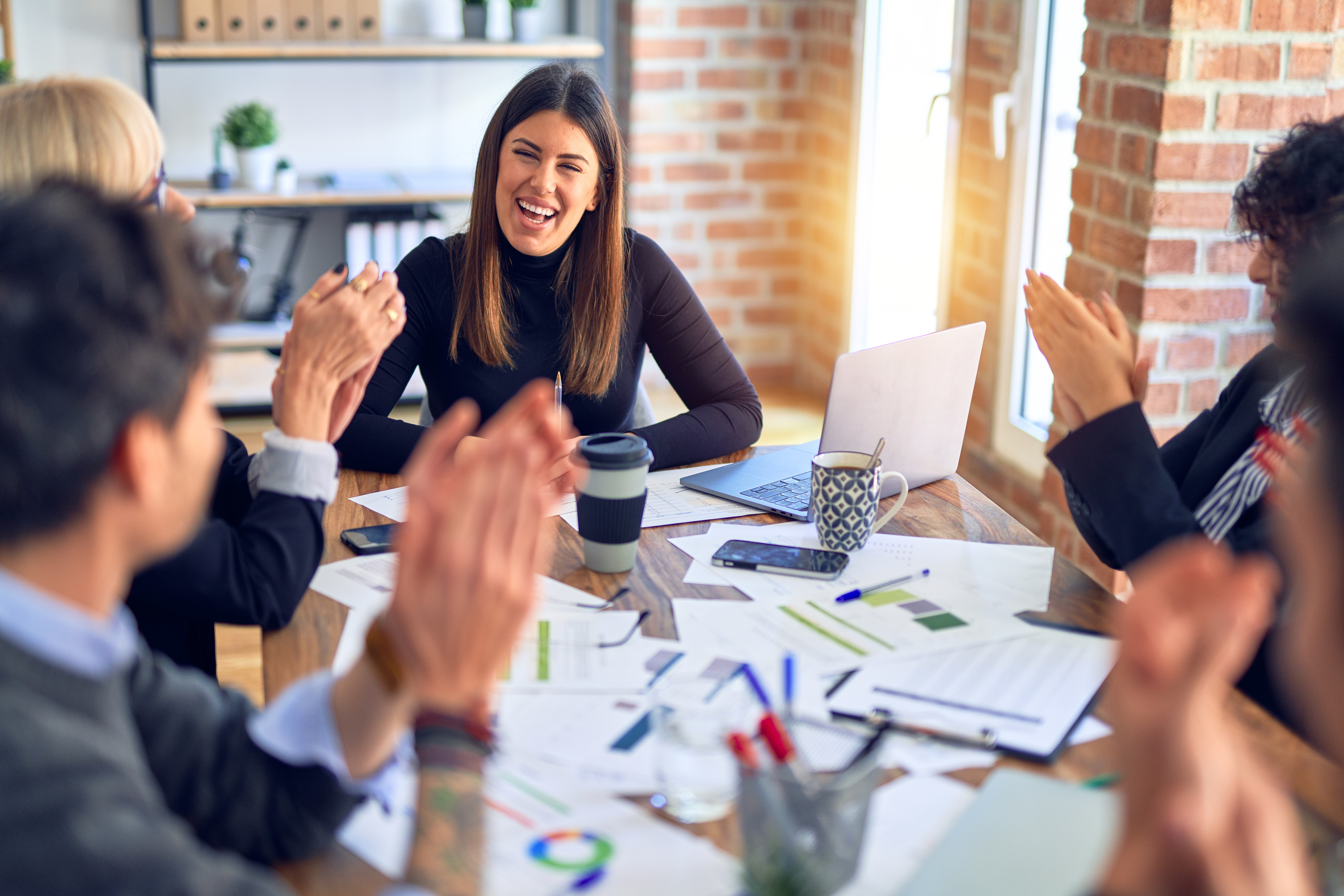 Group of employees smiling around a conference table