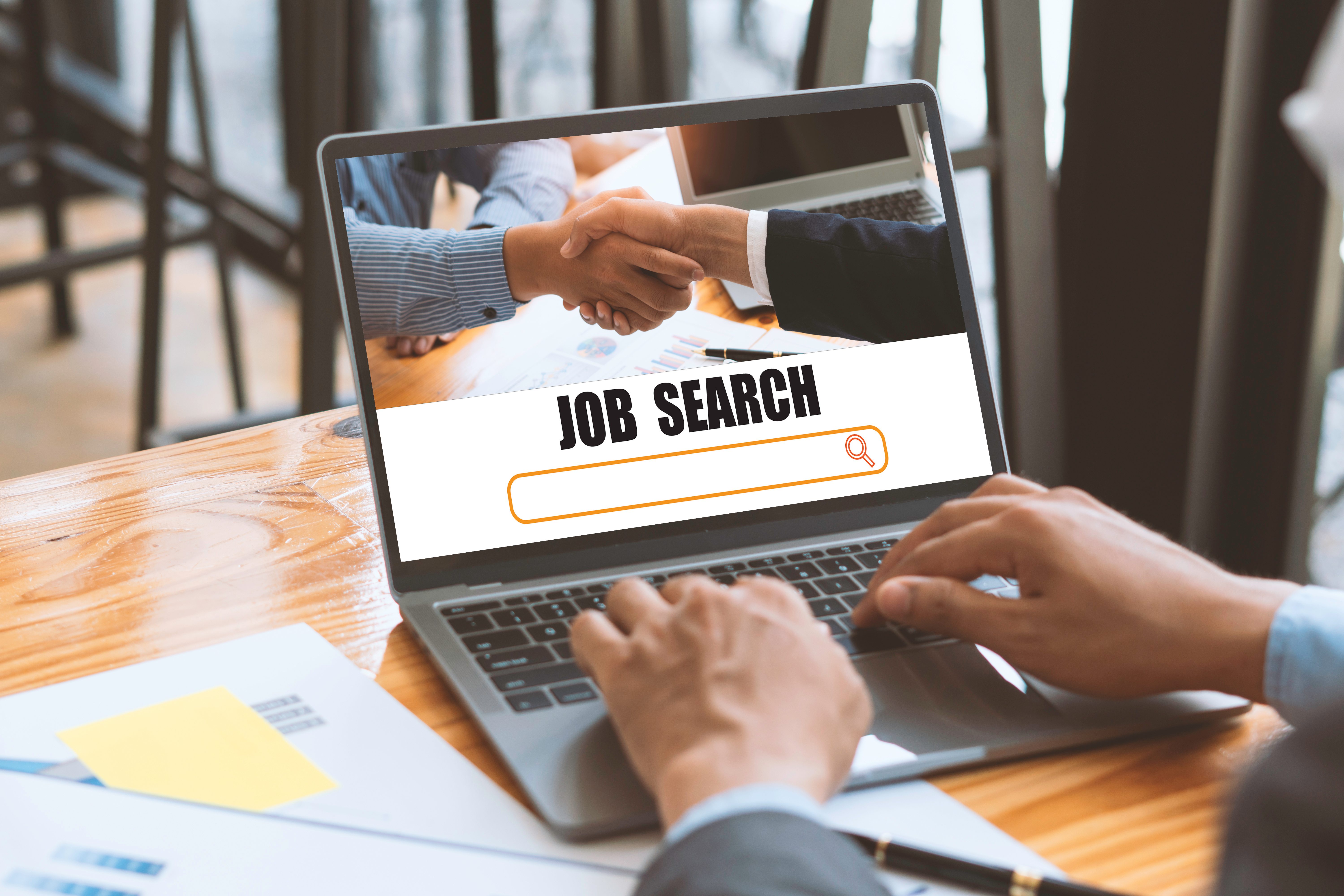 Man in suit looking for jobs on laptop