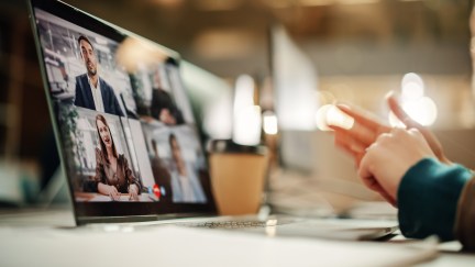Video call with four people in separate boxes on the screen.