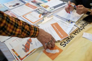 Man's hand picking up benefits form