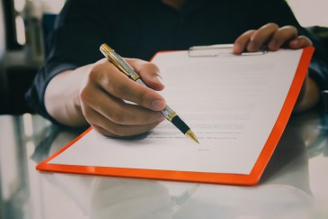 Man holding out a contract.