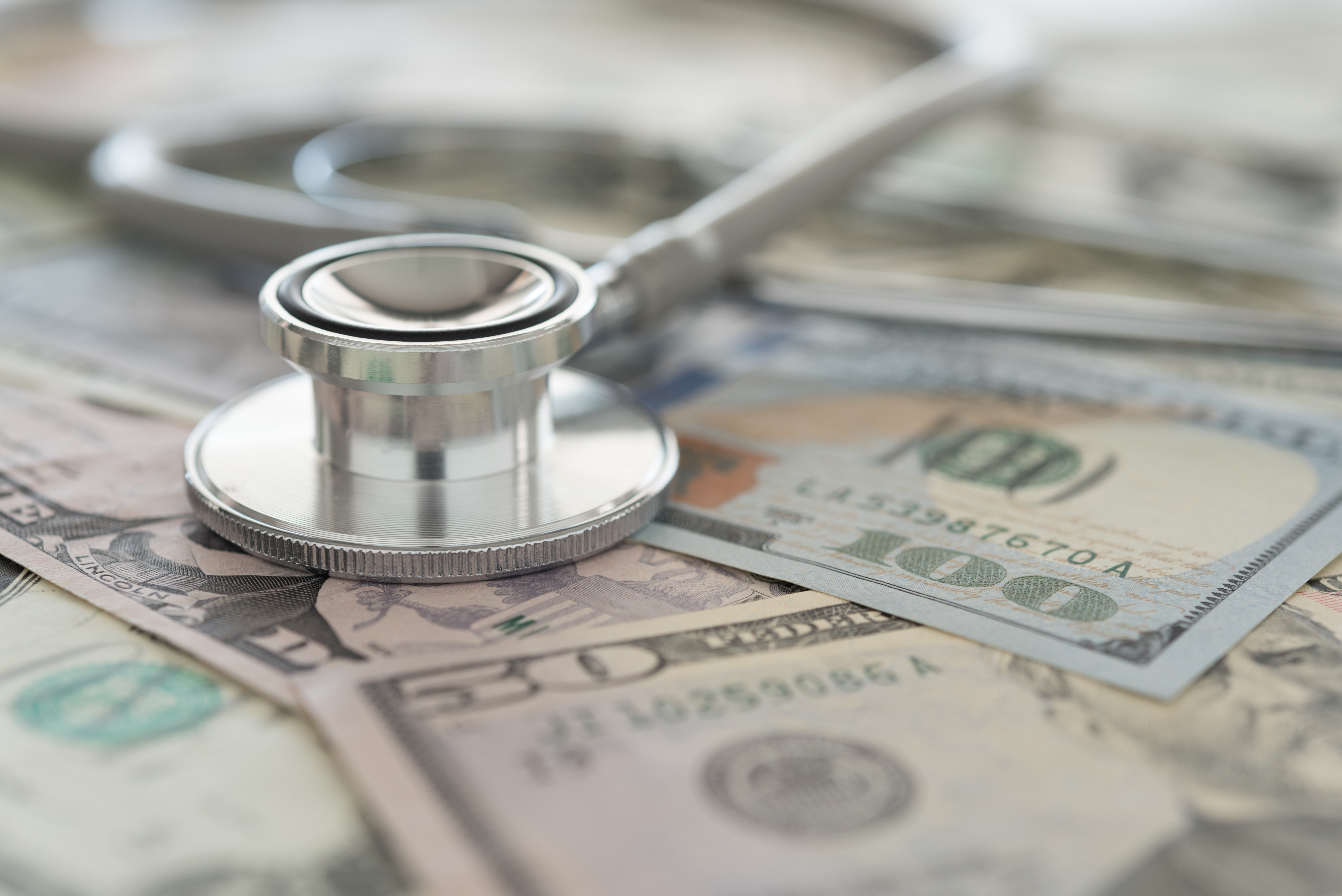 A doctor's stethoscope on top of money