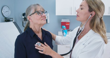 Woman getting heart checked by doctor with stethoscope