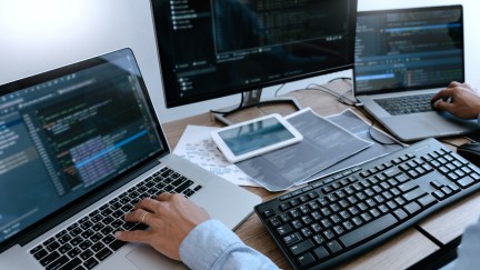 Man managing code on multiple different screens.