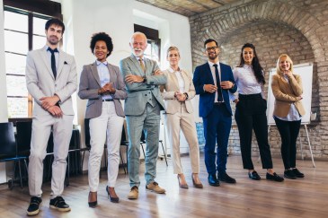 Group of employees standing in angled line in office