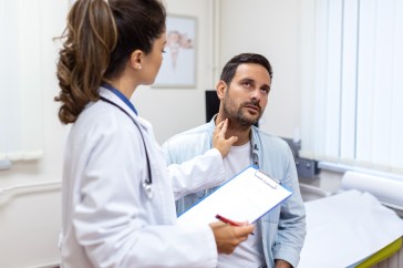 Female doctor checking the pulse of a male patient in a doctor's office