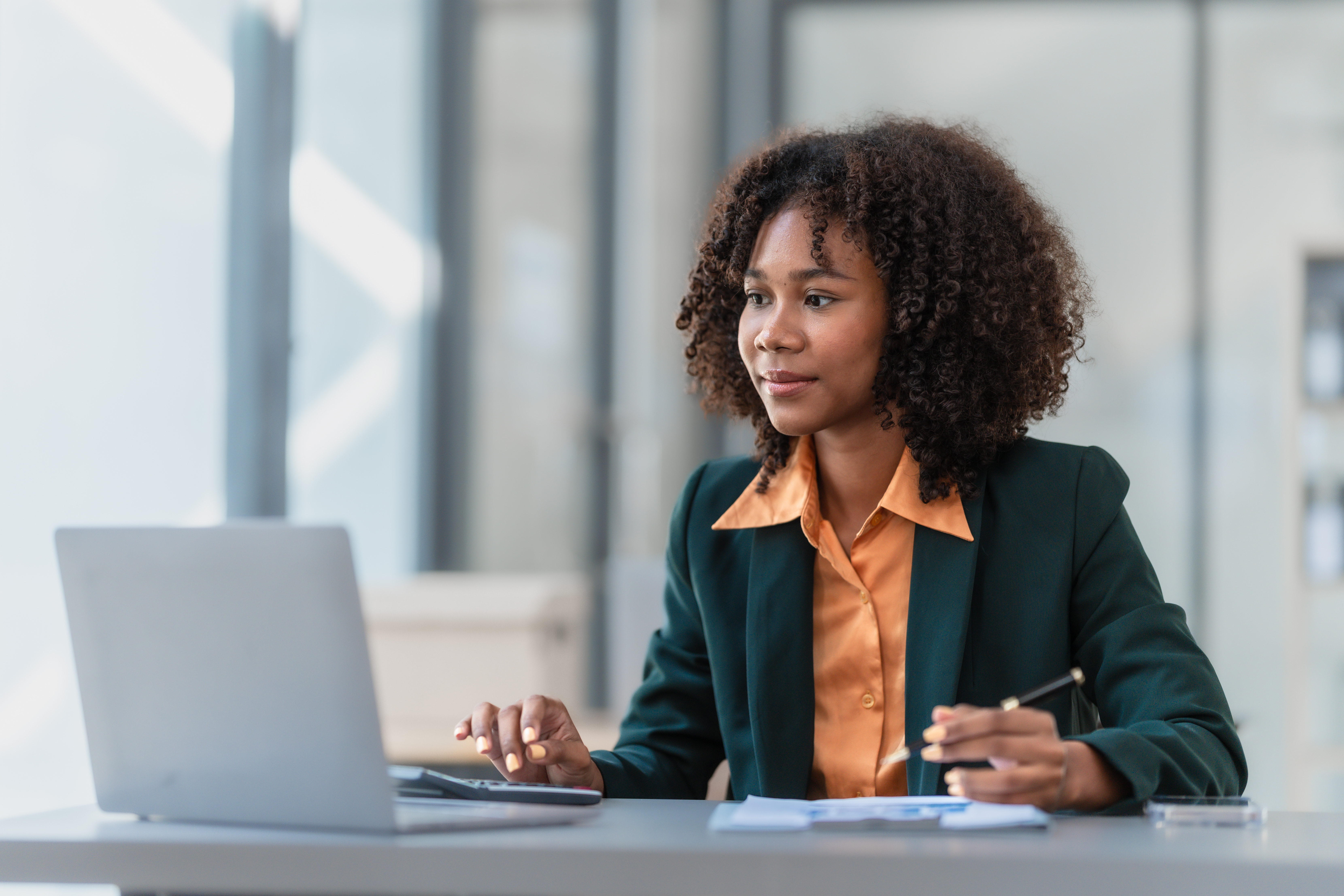 Female employee sitting at desk working on laptop