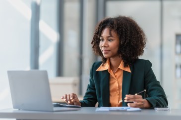 Female employee sitting at desk working on laptop