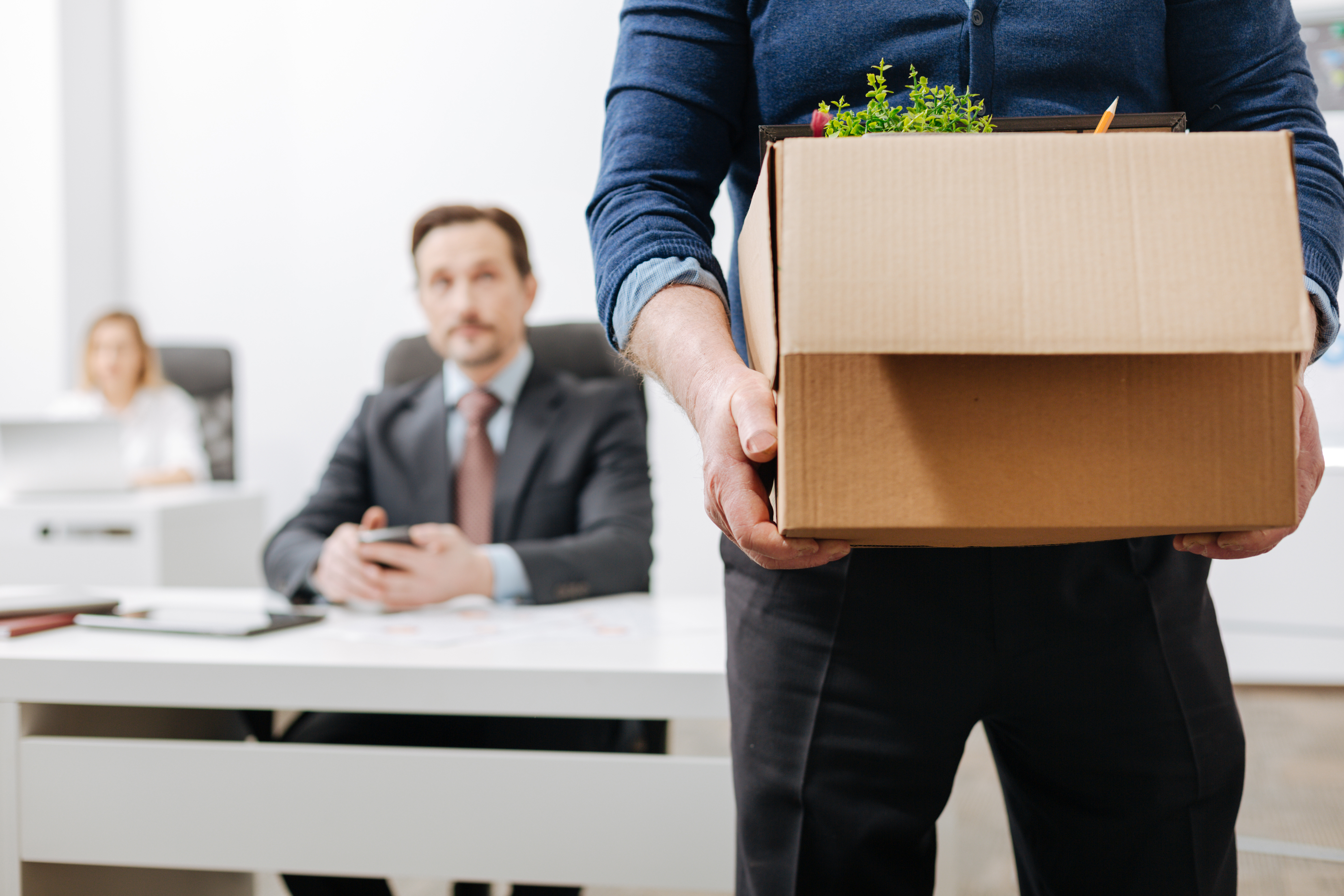 Man holding box with desk contents
