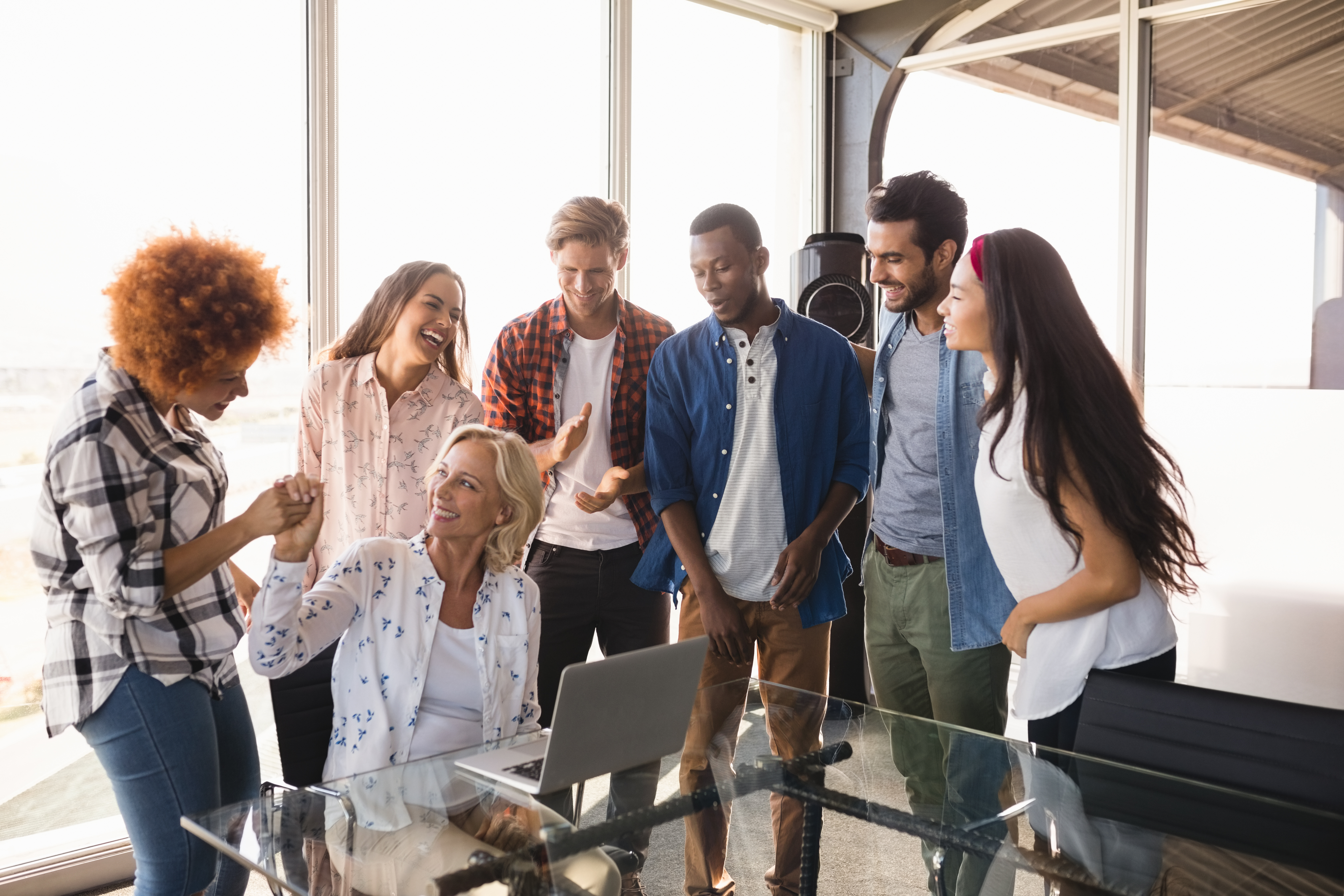 Employees of different ages in office laughing