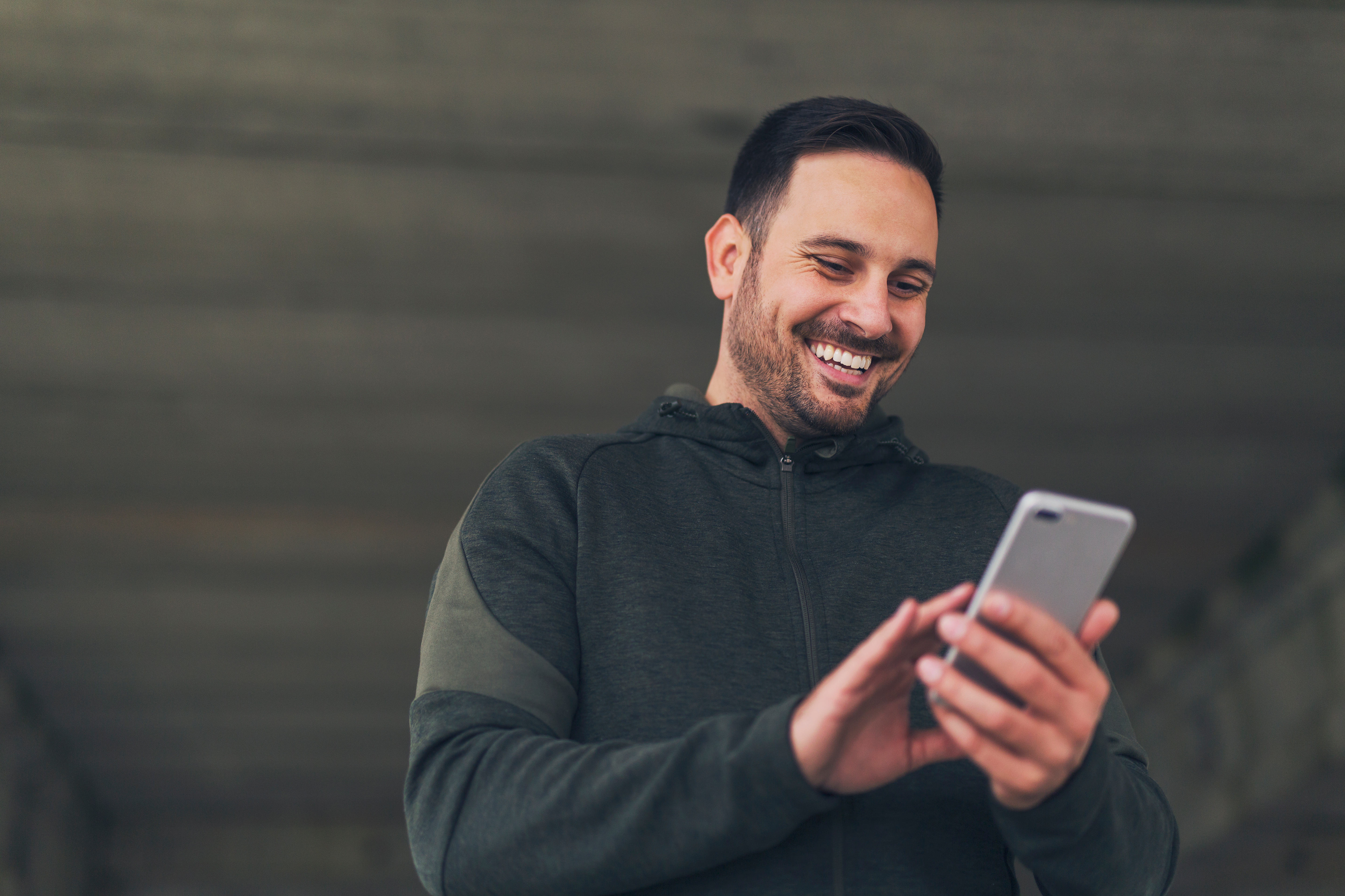 Man smiling holding cell phone