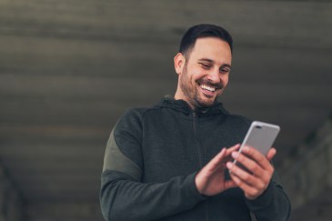 Man smiling holding cell phone