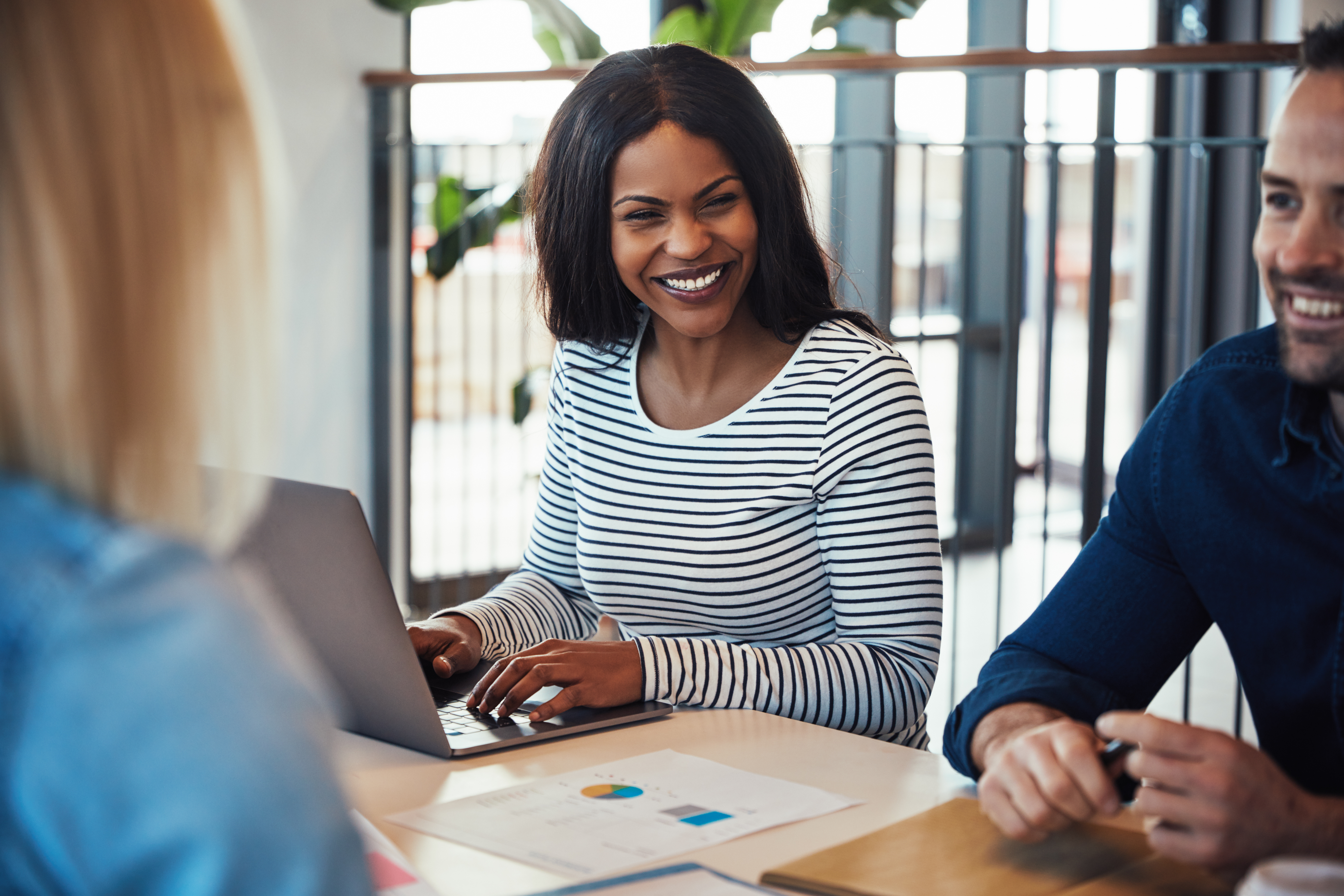 Woman smiling at a meeting with other coworkers