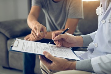 Person with doctor filling out form