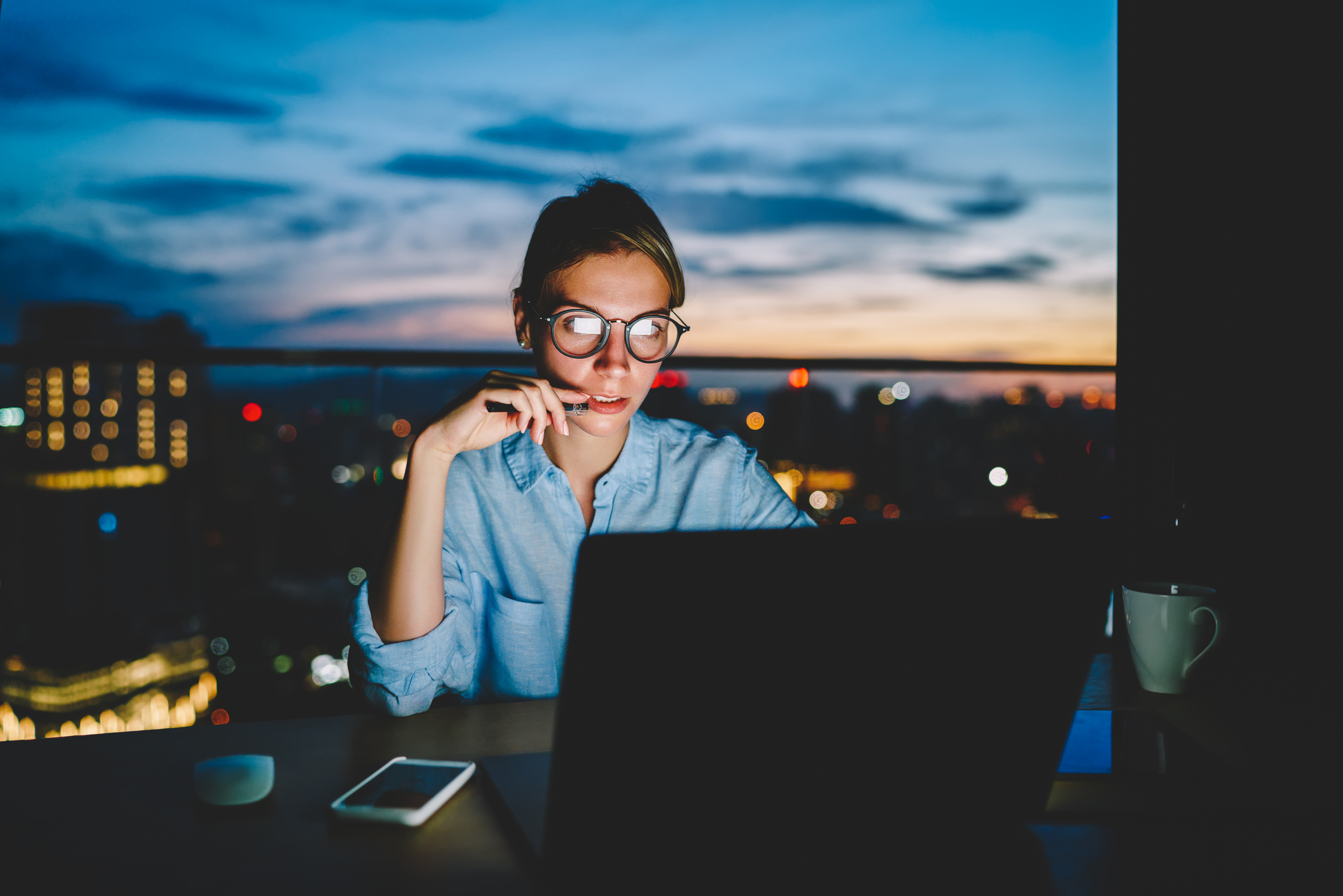 Woman working at her computer while sitting in the dark
