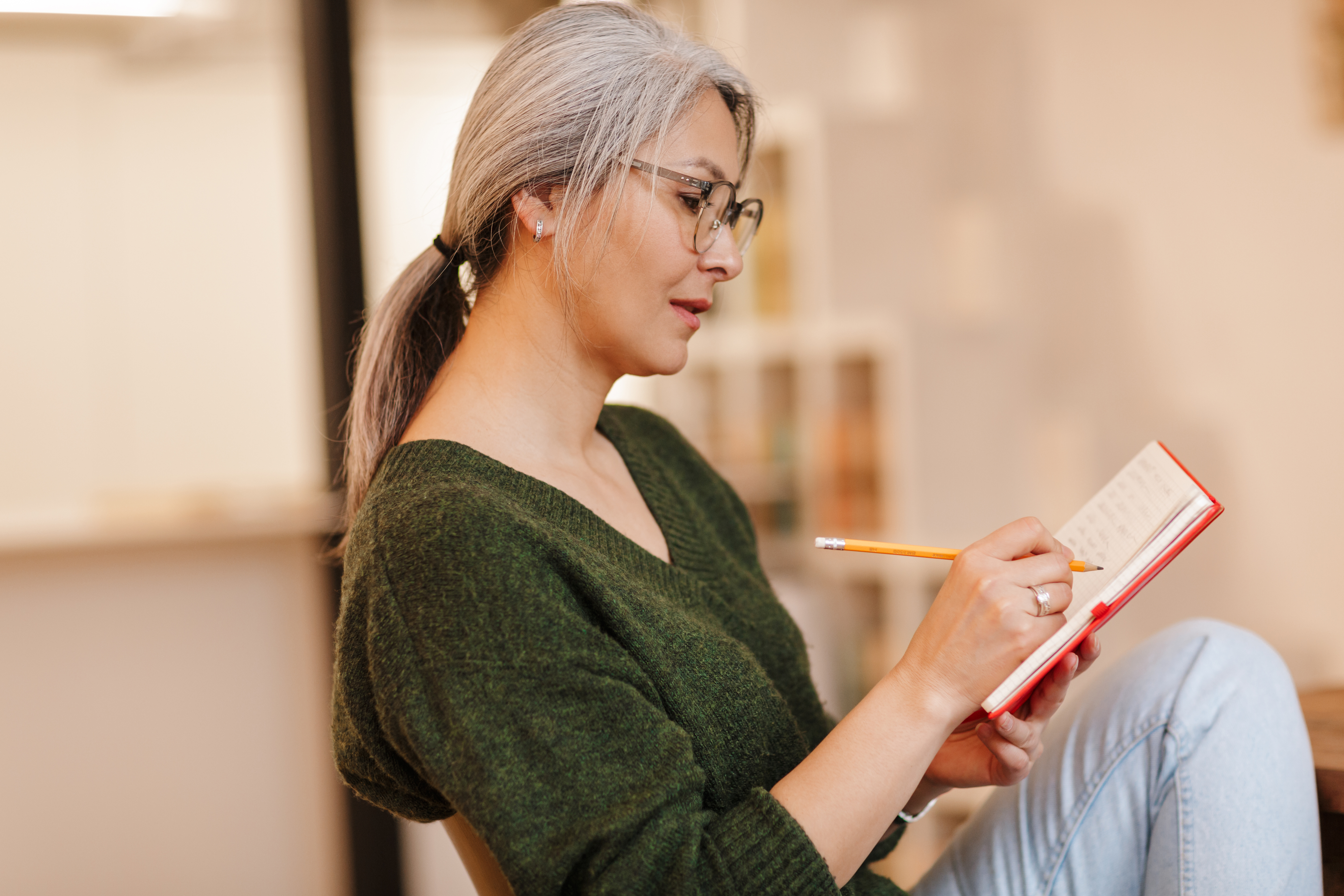 Woman sitting on a sofa writing in a journal