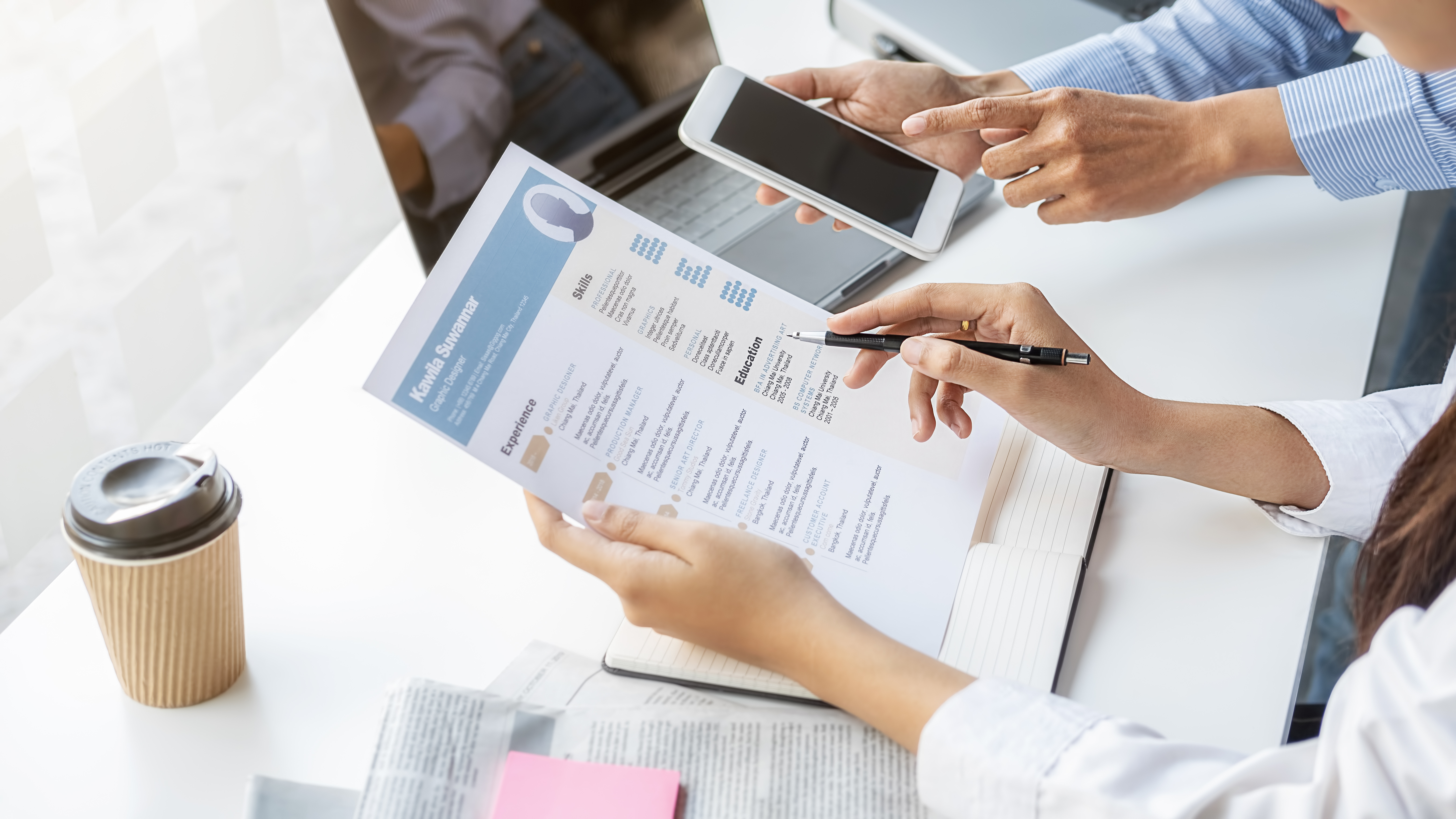 Hands holding resume and another person holding phone
