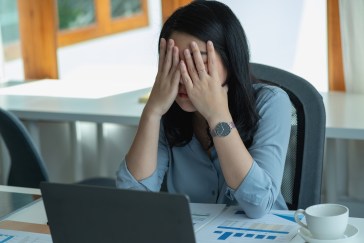 Women at work sitting with her head in her hands